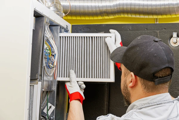 HVAC technician replacing furnace filter in Farmington Hills MI